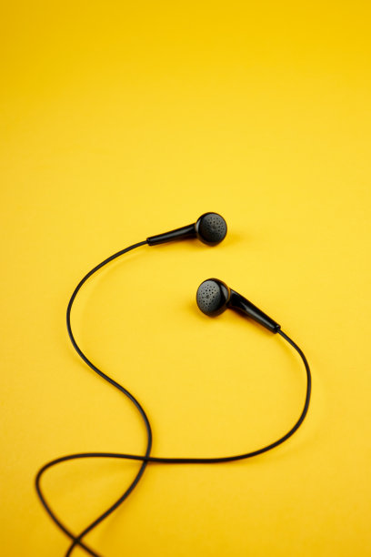 黑色耳机隔离在温暖的黄色时尚背景。音乐生活方式的概念。副本的空间。平的。图片下载