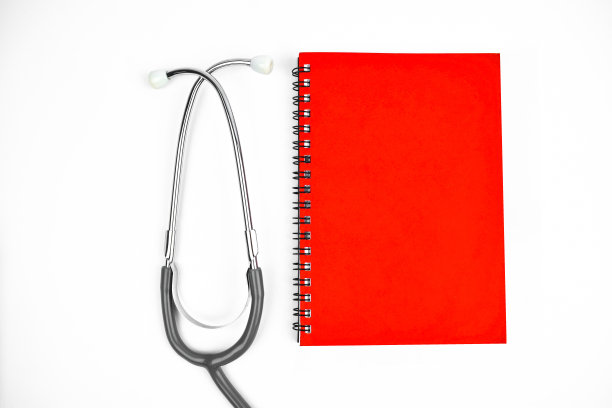 一本红色日记和一个听诊器并排放在一个孤立的白色背景上图片下载