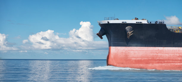 大红色商船在海上航行的特写镜头。图片下载