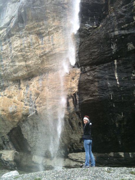 快乐的女人站在瀑布旁边图片下载