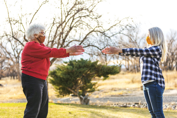 成年成年女性和老年成年女性因传染病大流行戴口罩并表现出社交距离图片下载