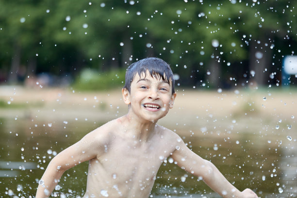 男孩在湖中飞溅水花图片下载