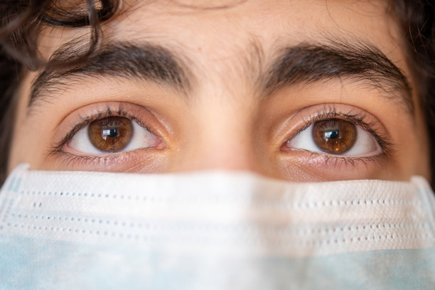 冠状病毒，戴着防护口罩的青少年的眼睛图片下载