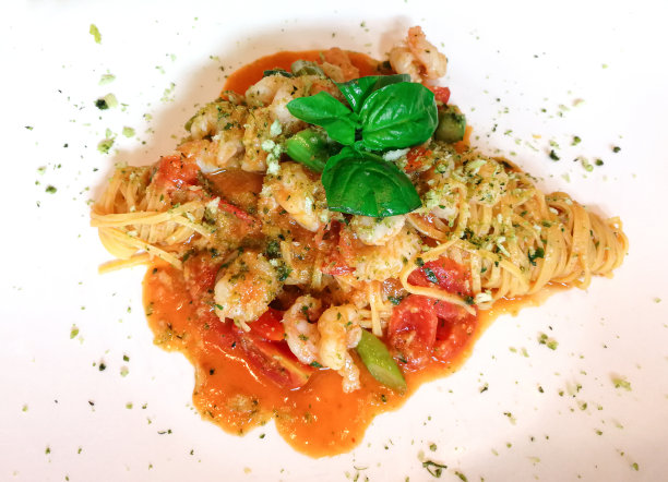 意式小虾拌番茄酱。一组红虾混合草药在白色盘子图片下载