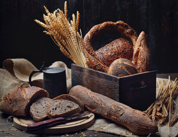 黑色背景的乡村木桌上混合烘焙的面包卷图片下载