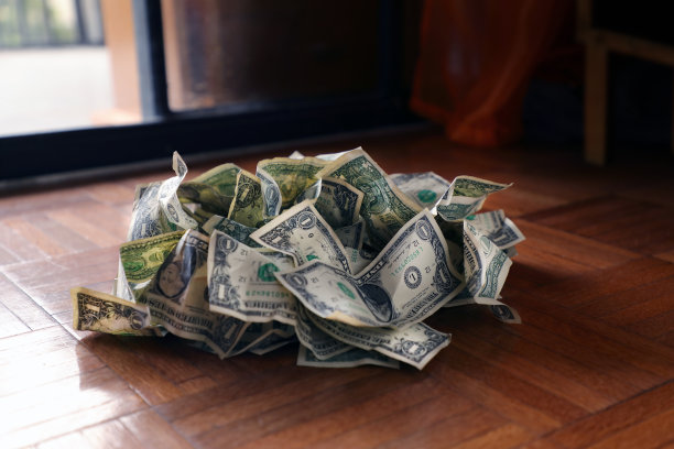 硬木地板上一堆皱巴巴的旧一美元钞票图片下载