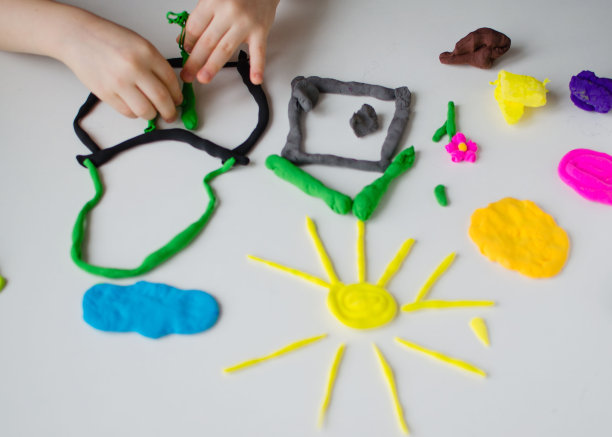 孩子的手玩着彩色的粘土。自制plastiline图片下载