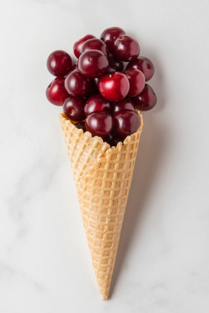 白色大理石背景上的华夫蛋筒樱桃浆果。夏天食物的概念。前视图。平躺图片下载