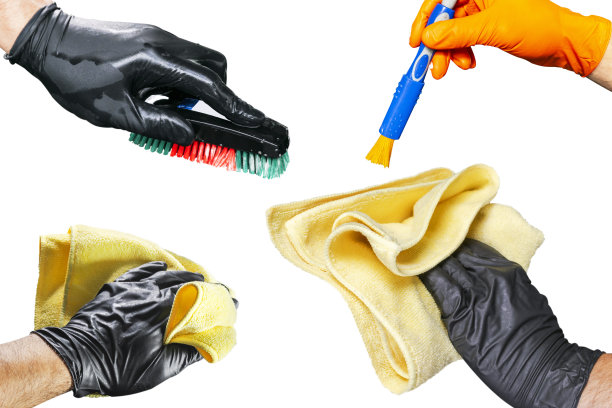 清洗的概念。一个男人的手与刷子孤立的白色背景。工人清洗。用泡沫和刷子清洗。清洁概念-手戴黑色橡胶防护手套图片下载