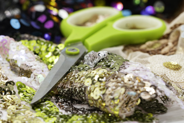 剪刀在彩色亮片的布料上。颜色的亮片。亮片的质感....图片下载