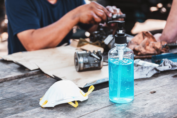 卫生口罩和酒精洗手液放在木桌上。图片下载