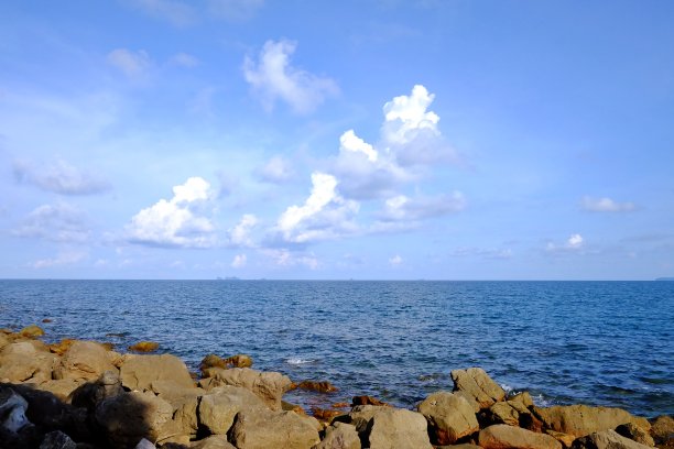 蓝色的天空，白色的蓬松的云和蓝色的海图片下载