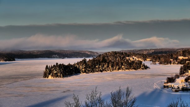 在日出的映照下，冰冻的河流和群山环绕的岛屿图片下载