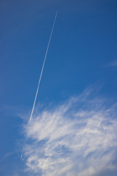 一架飞机在晴朗的蓝天中穿过云层图片下载