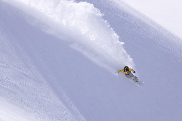 滑雪板在深粉中转弯。图片下载