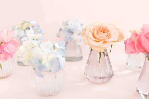 饰以盛开的蓝绣球花、香豌豆石竹、灌木玫瑰等装饰于粉红色背景的小水晶花瓶中。设计、创意。3月8日的国际妇女节和2月14日的情人节图片下载