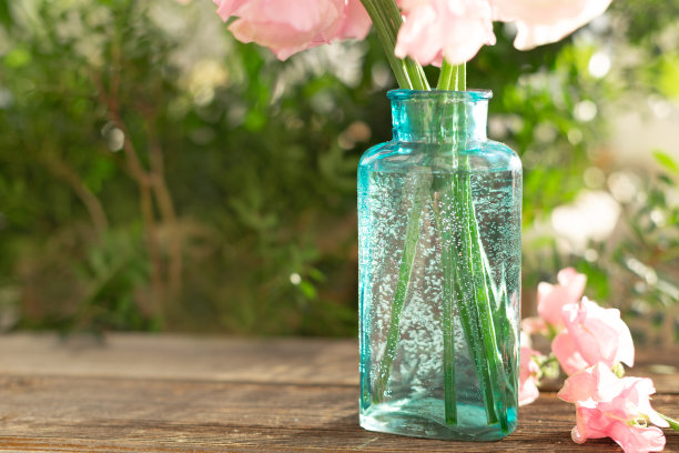 一束粉红色的甜豌豆在美丽的透明花瓶上木制的背景。家花园,乡村。春天的概念。3月8日的国际妇女节和2月14日的情人节图片下载