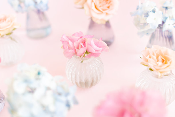 饰以盛开的蓝绣球花、香豌豆石竹、灌木玫瑰等装饰于粉红色背景的小水晶花瓶中。设计、创意。3月8日的国际妇女节和2月14日的情人节图片下载