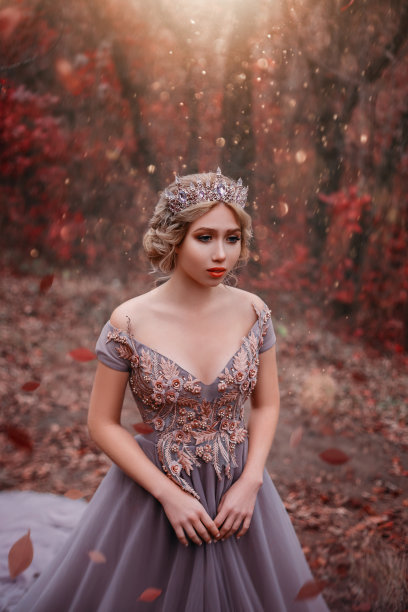 年轻漂亮的金色头发女子，公主在秋天的森林里行走图片下载