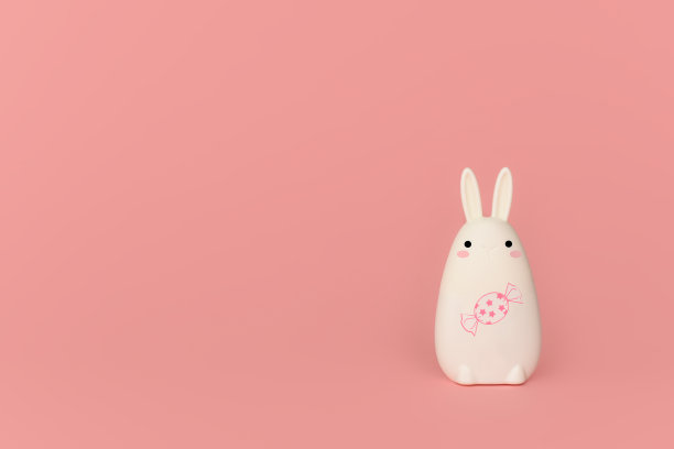 粉红色背景上有糖果的有趣白兔。副本的空间。图片下载