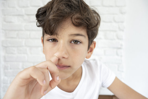 小男孩用手指在鼻子上钻孔图片下载