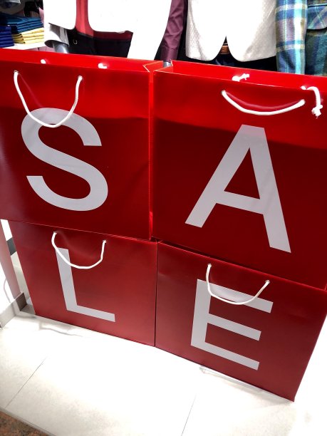 商店环境中的零售标志形象，红色购物袋上的白色销售文字图片下载