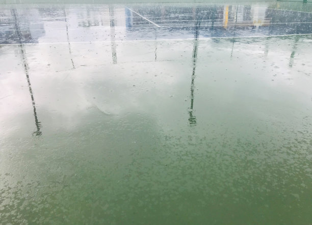 下雨时，聚光灯投射在网球场上的影子图片下载