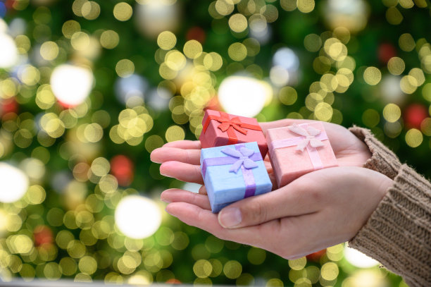 裁剪的镜头有人手拿着一小群包装的礼品盒。图片下载