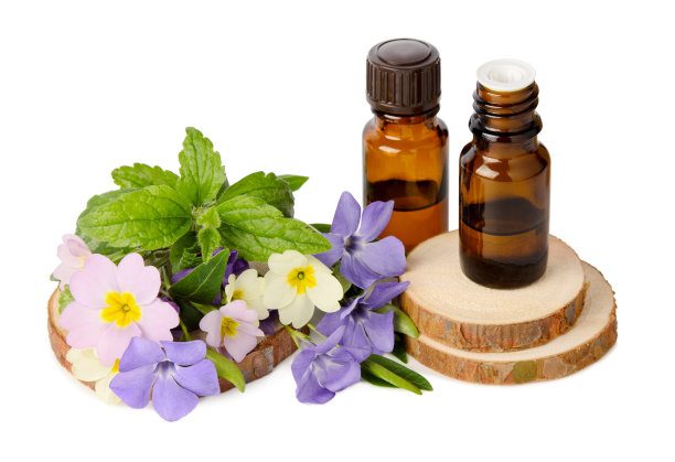 玻璃瓶中的天然精油和在白色背景上分离的草药芳香图片下载