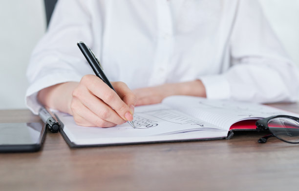 商务女性用钢笔在记事本上写字图片下载