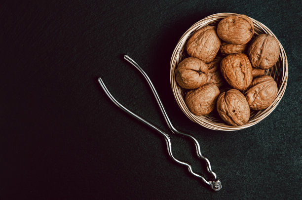 核桃与胡桃夹在黑色背景，俯视图。图片下载