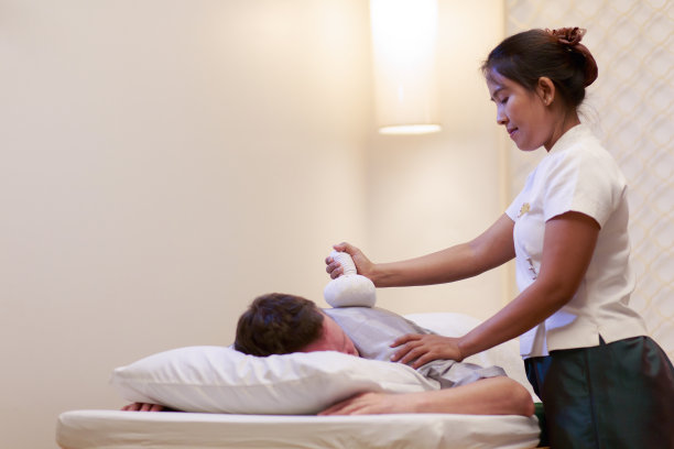 亚洲男子得到泰国草药热敷按摩温泉。图片下载