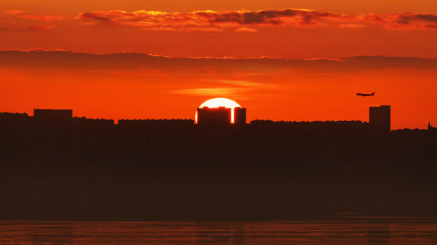 太阳从城市上空升起图片下载