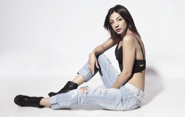 侧面的美丽的女人坐在白色的地板前面的白色背景图片下载