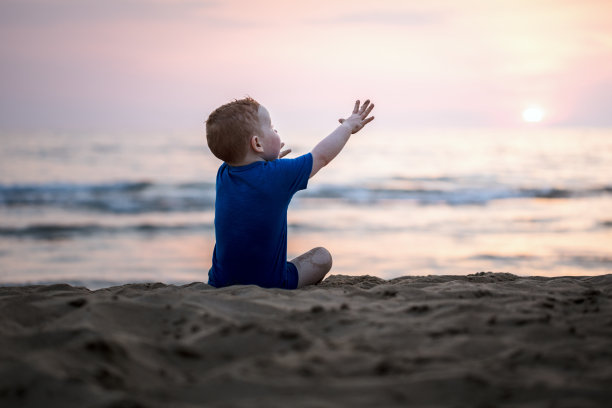 海滩上孤独的小男孩图片下载