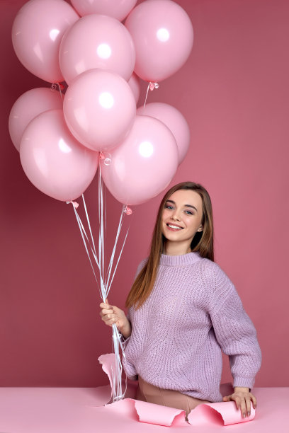 手持粉色气球站在破纸洞中的女子图片下载