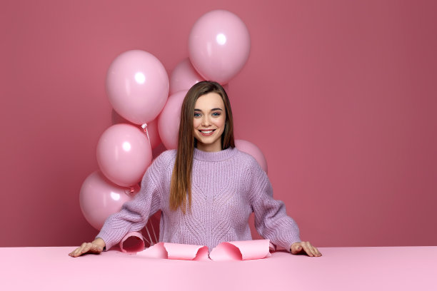 手持粉色气球站在破纸洞中的女子图片下载