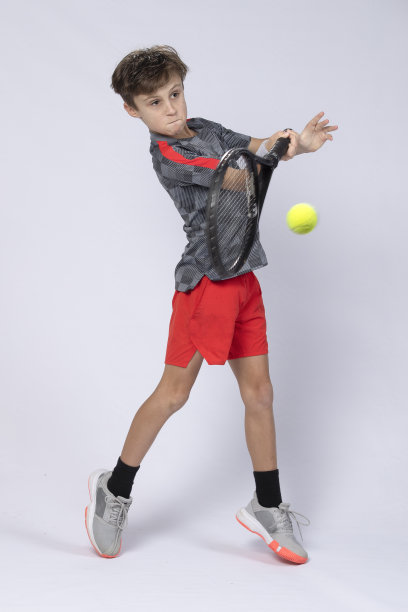 男孩在白色背景上打网球图片下载