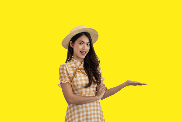 幸福的亚洲女人与开放的手掌孤立在黄色的背景图片下载