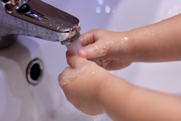 小男孩在水槽的水龙头下洗手。Сoncept卫生、疾病预防、病毒控制和应对新型冠状病毒感染的原始措施。有选择性的重点。图片下载