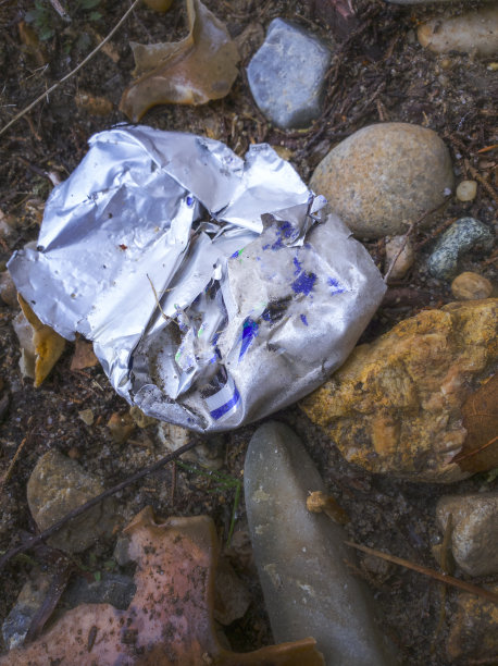 岩石海滩上破碎的乡村铝罐图片下载