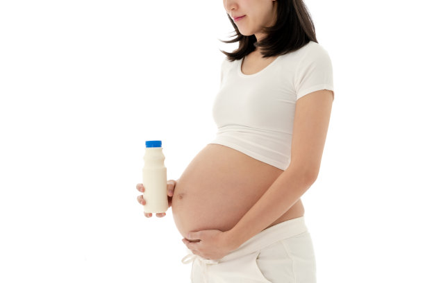 亚洲孕妇站着拿着一杯牛奶图片下载