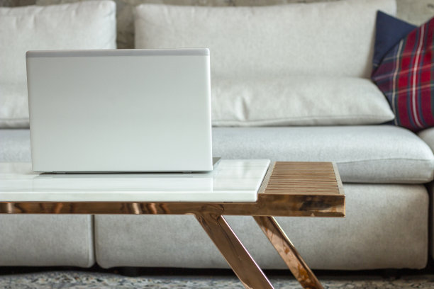 时尚现代的室内。沙发背景的桌子上放着笔记本电脑。图片下载