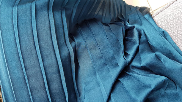 褶皱织物纹理的蓝色条纹纺织品特写。带有褶边和条纹的休闲服褶皱。时尚背景与复制空间。图片下载