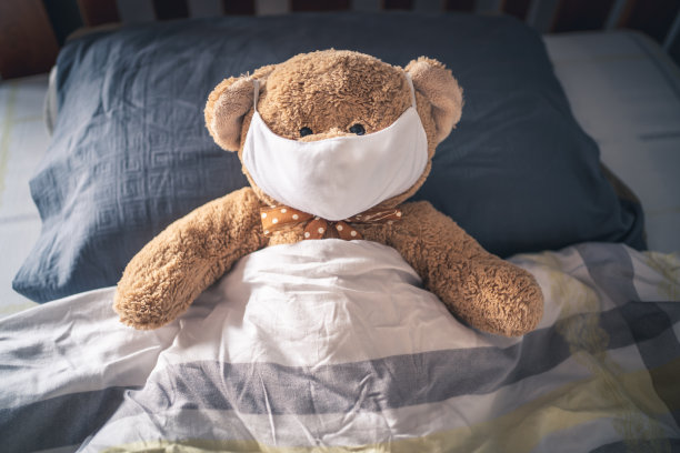 泰迪熊戴着面具，睡在床上图片下载