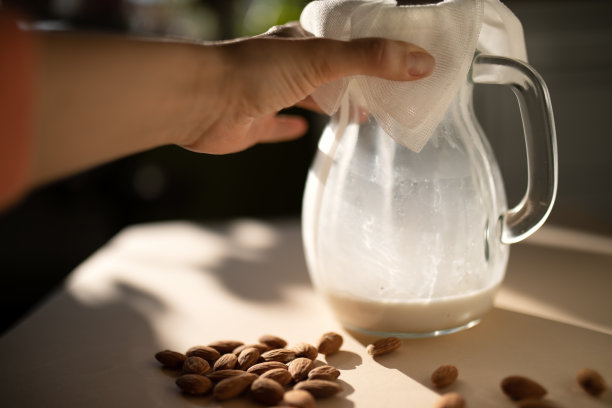 女人的手拿着一壶杏仁奶。图片下载