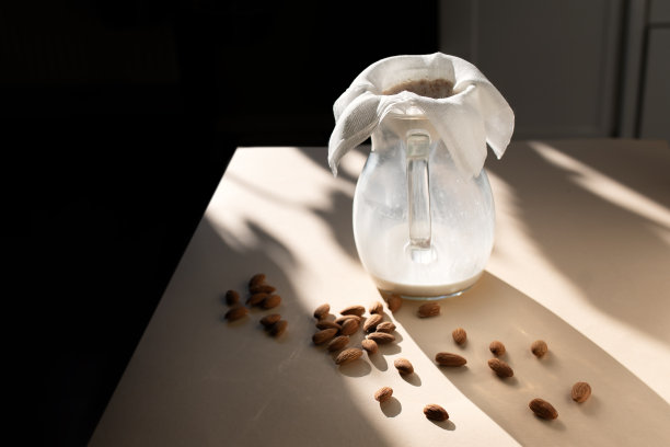 阳光下的桌子上放着一罐杏仁牛奶。图片下载