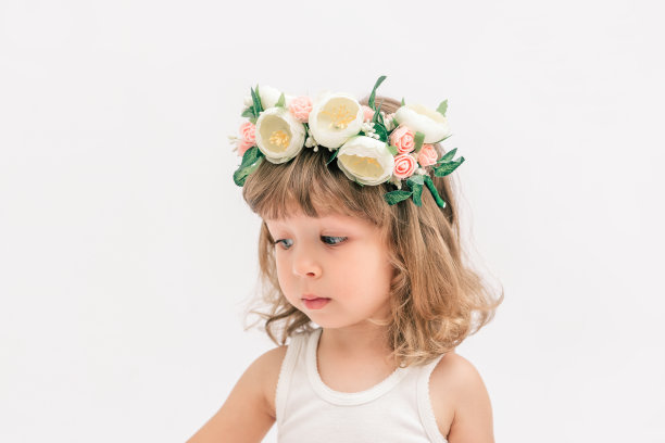 可爱有趣的小女孩戴着花环庆祝生日。简约的白色背景。三岁庆典。图片下载