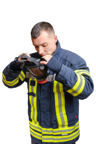 身穿制服的年轻消防员在头上戴上面罩式呼吸器。图片下载