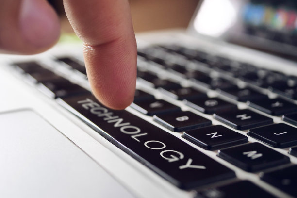 当一个男人按下业务按钮时，一个笔记本电脑键盘的特写图片下载